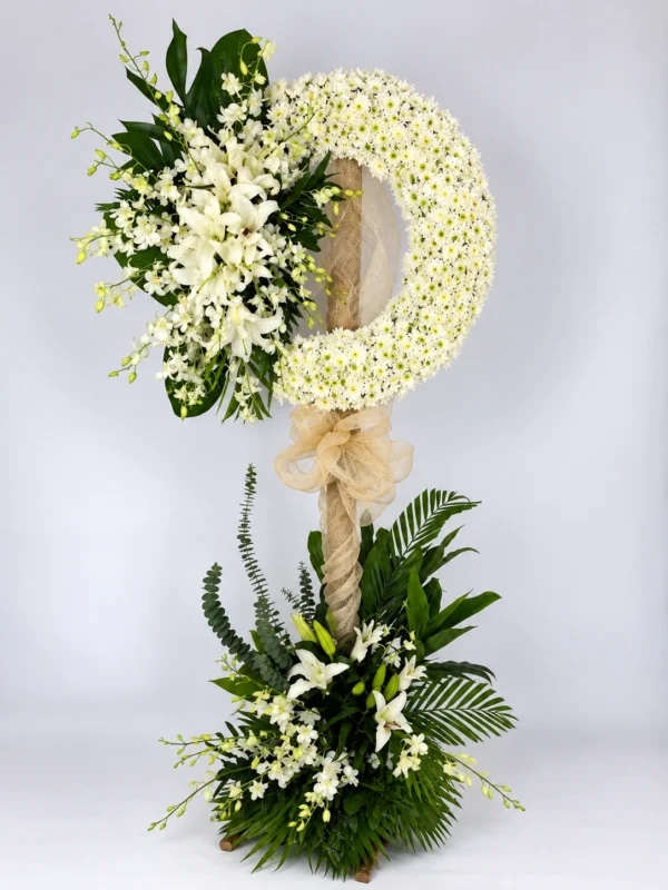 Halo white mum funeral wreath stand with white lilies, orchids and a flower base