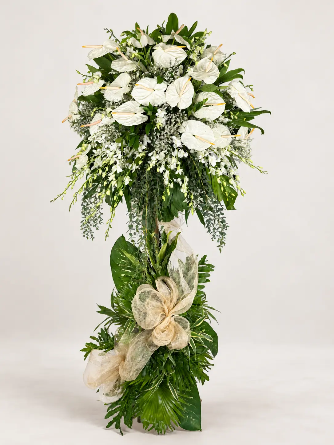 Grace white anthurium and dendrobium orchid one-layer funeral stand with tropical leaf base and cream bow